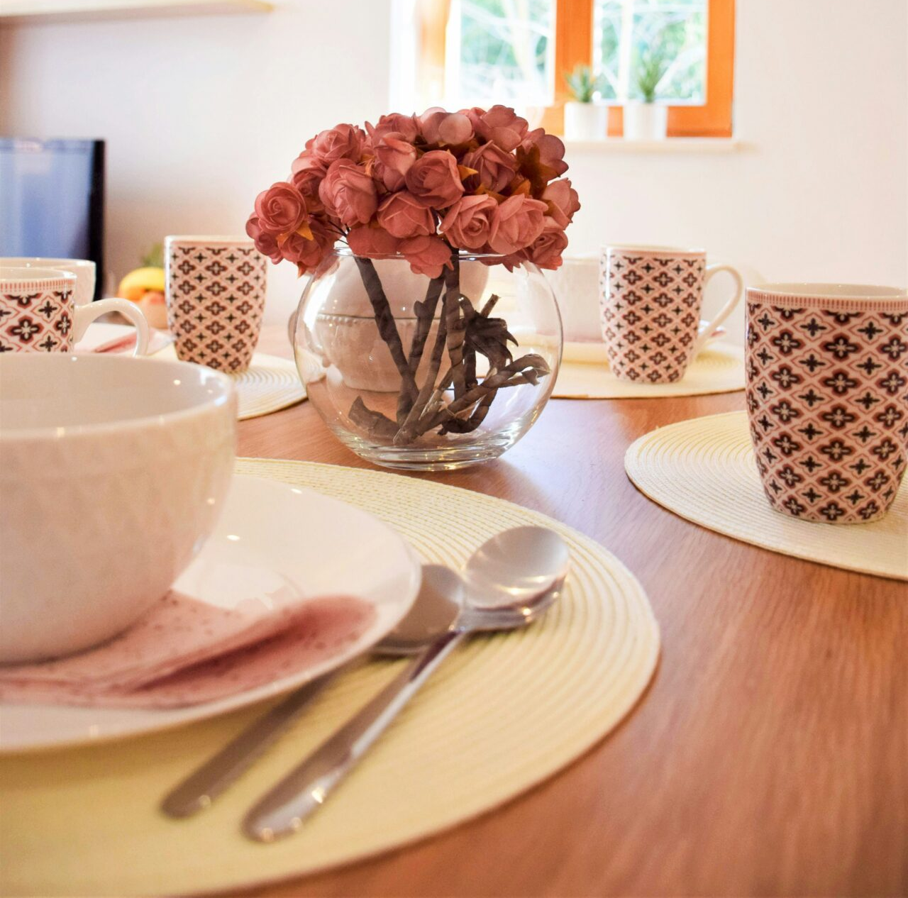 Gedeckter Tisch mit Tassen und einem Blumenstrauß in angenehmer Atmosphäre